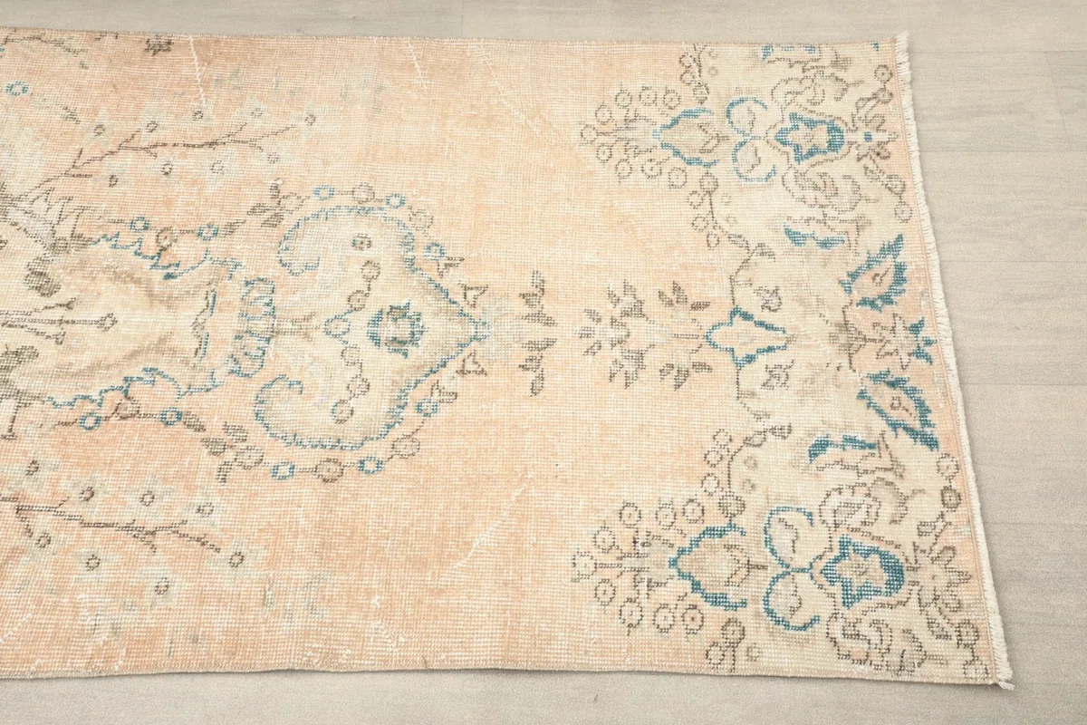 Close-up detail of one end of the runner rug, showing the floral motifs and color variations.