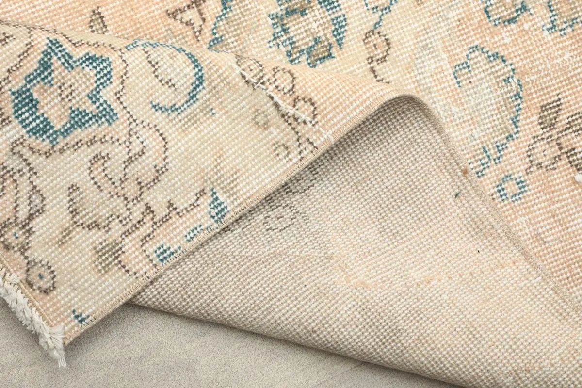 View of the back of the rug, showing the tightly woven cotton foundation and knotting.