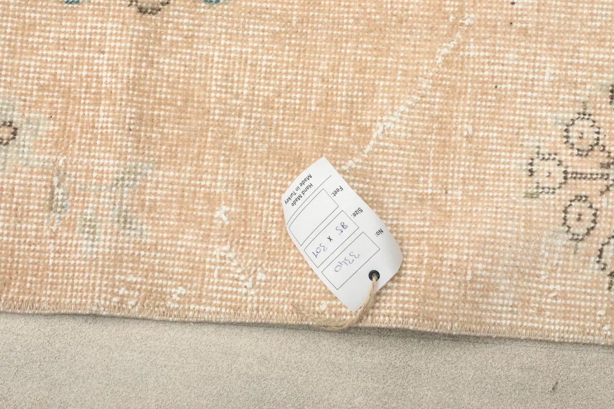 Close-up of the rug with a label displaying its dimensions and origin, confirming details.