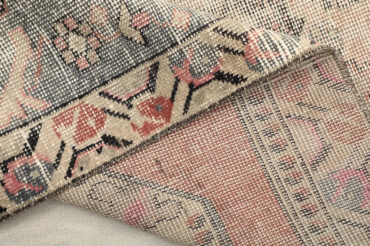 View of the reverse side of the rug, showing the hand-knotted construction and fringe detail