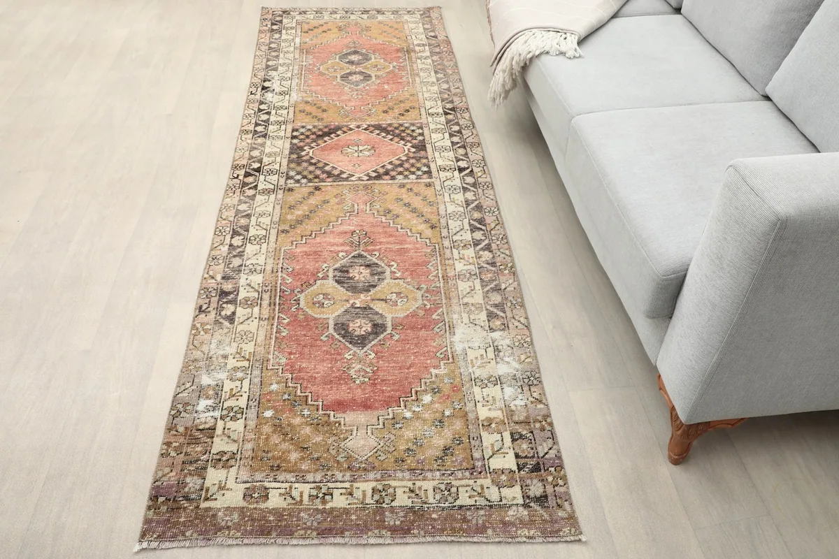Vintage rust runner rug in a modern living room setting next to a light gray sofa