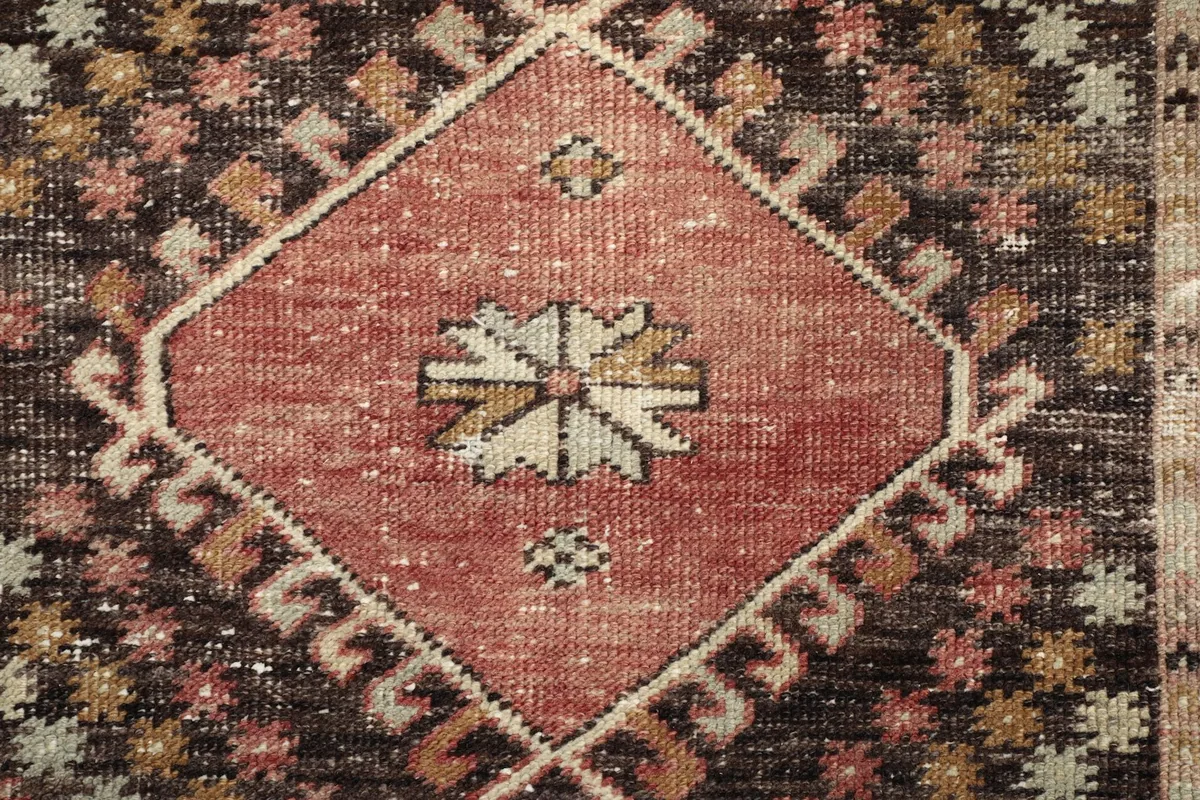 Close-up of the intricate design within a rust and black colored medallion