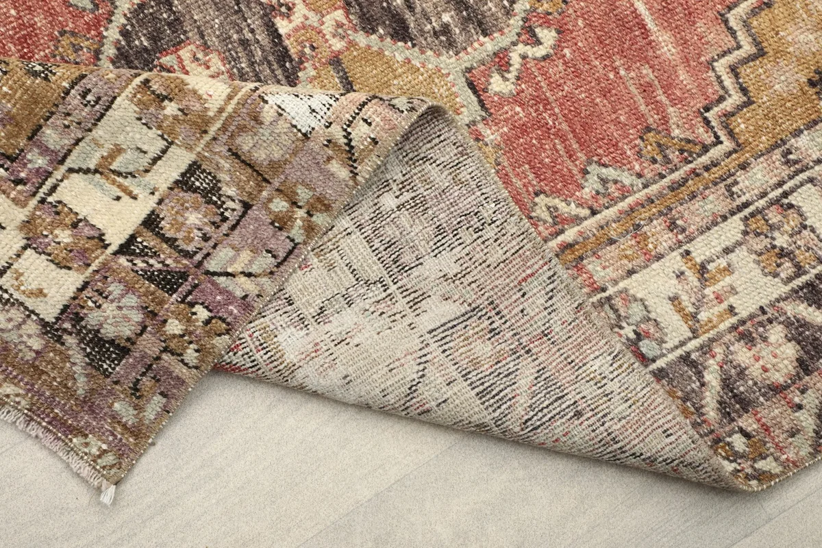 Folded corner of the rug revealing the thickness and construction of the vintage piece