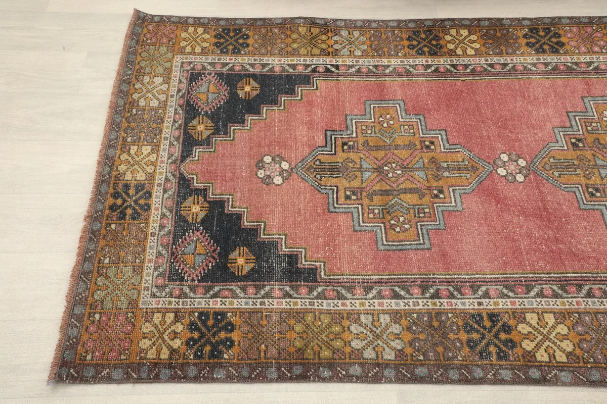 Angled close-up showing the rug's colors and the intricate designs of its main field and border
