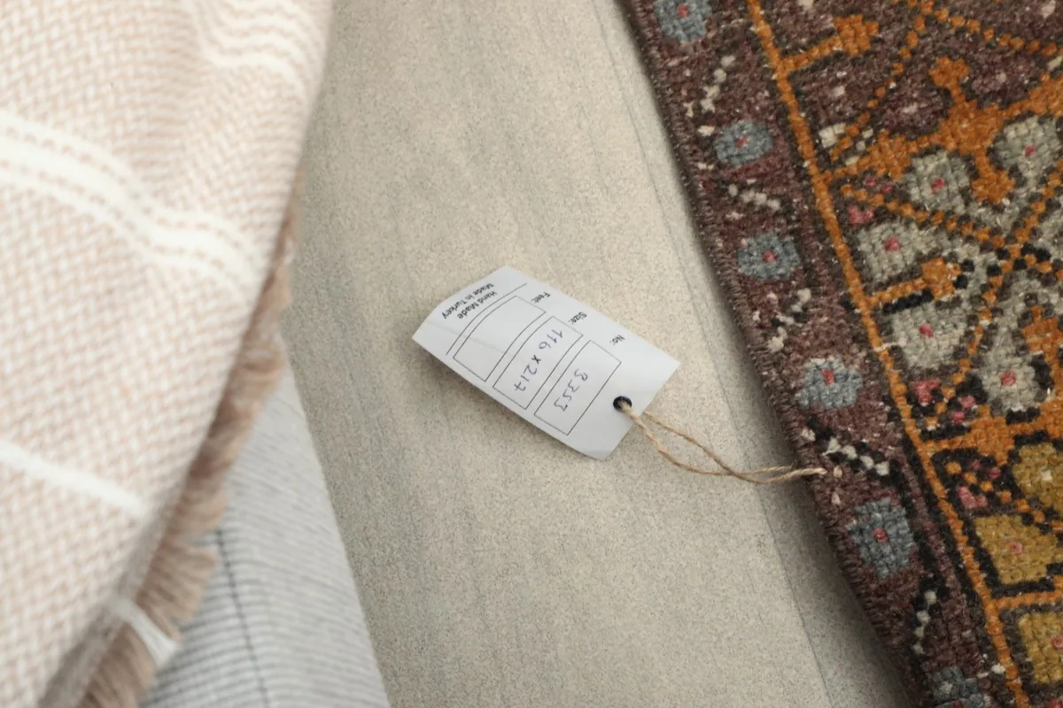 Close-up of the RugsKilim product tag attached to the vintage wool rug