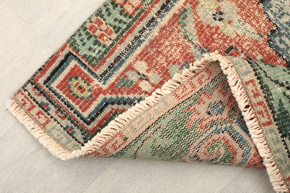 View of the back of the vintage hand-knotted rug, showing the cotton foundation and fringes