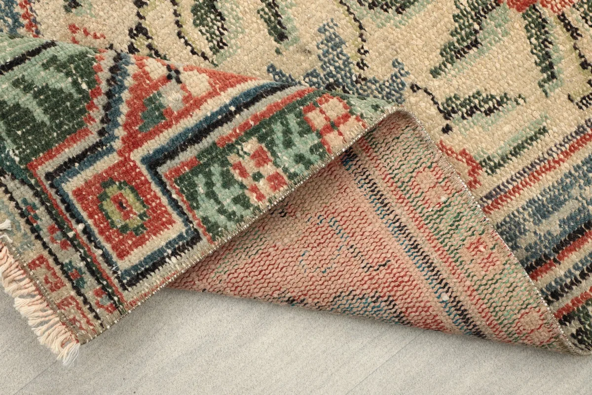 Close-up of the reverse side of the vintage rug, revealing the knotting and foundation