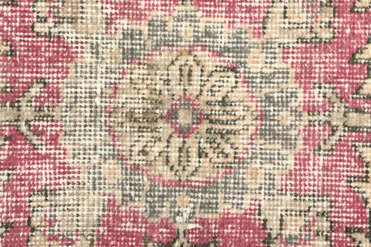 Detailed close-up of a central floral medallion motif with beige and gray tones