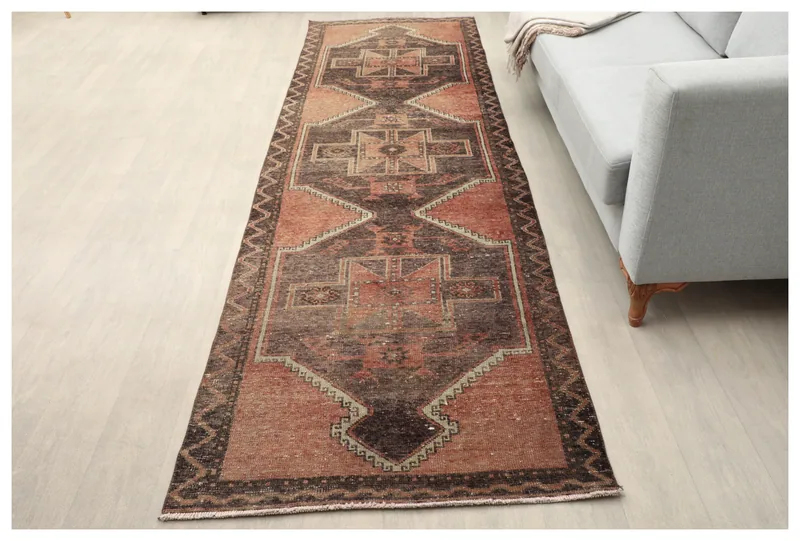 Full top view of the rust and brown tribal geometric runner on a light floor