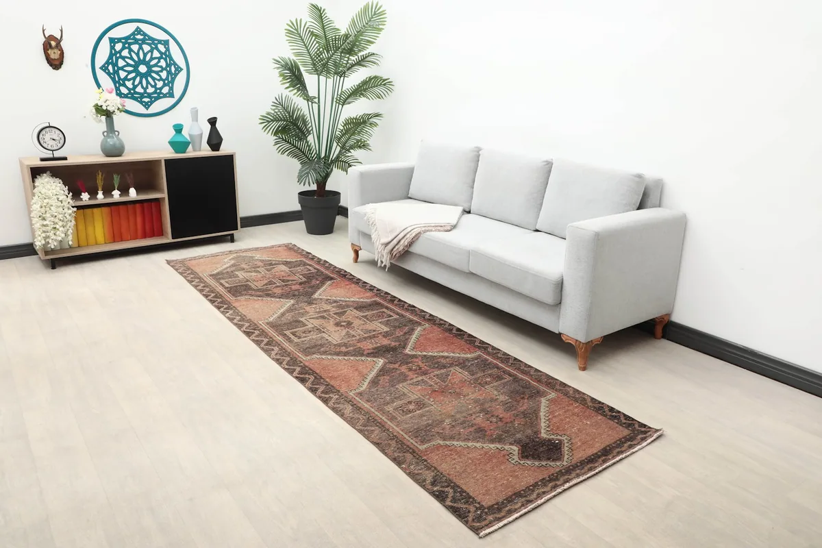 Long view of the vintage runner in a room setting with a light gray sofa and plant