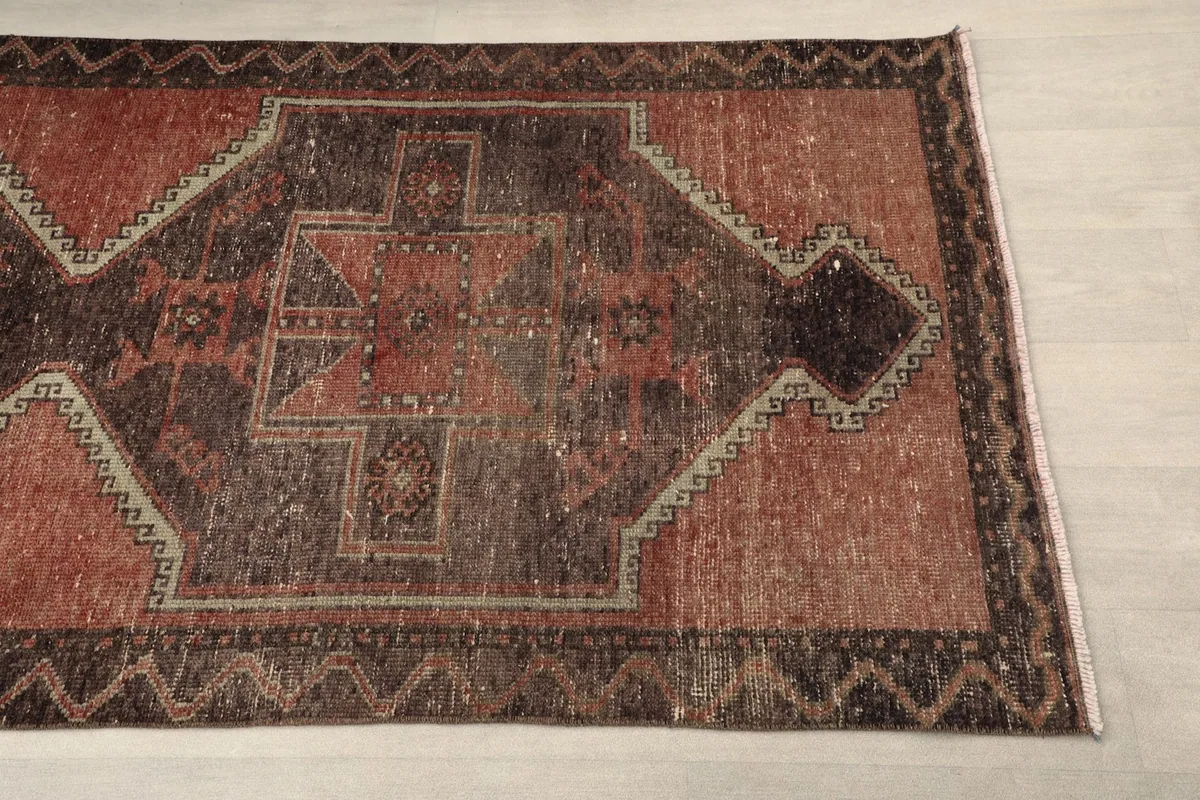 Close-up detail of the rust and brown geometric pattern and border of the runner