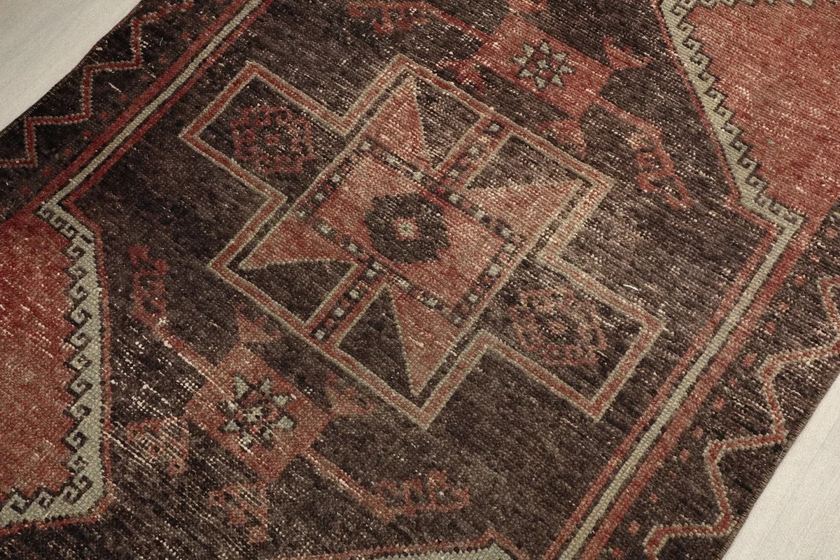 Detailed view of the central tribal geometric motif with rust, brown, and beige tones