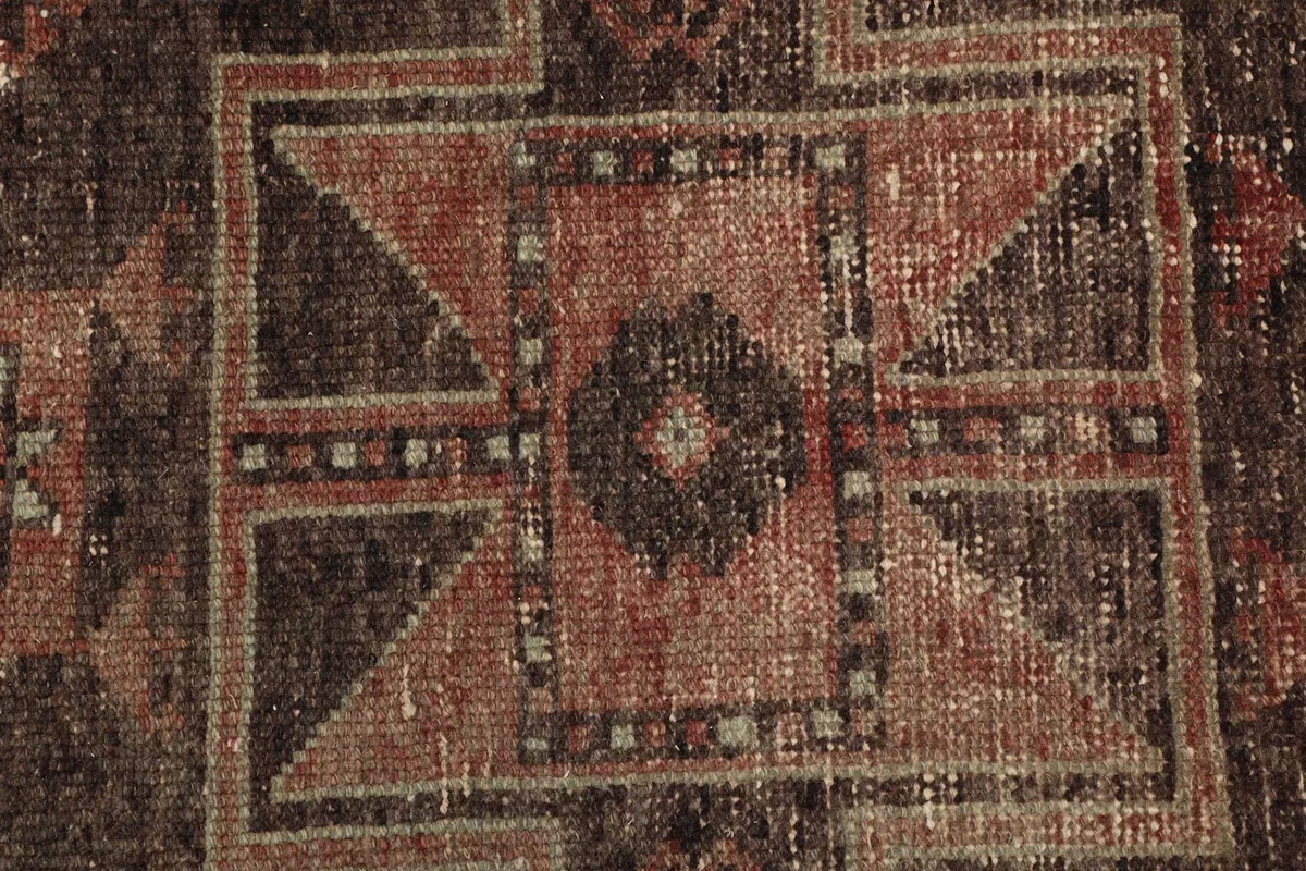 Close-up showing the low pile texture and intricate hand-knotted details of the rug