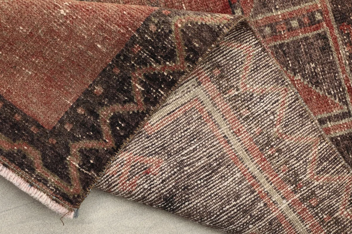View of the reverse side of the hand-knotted rug, revealing the cotton foundation