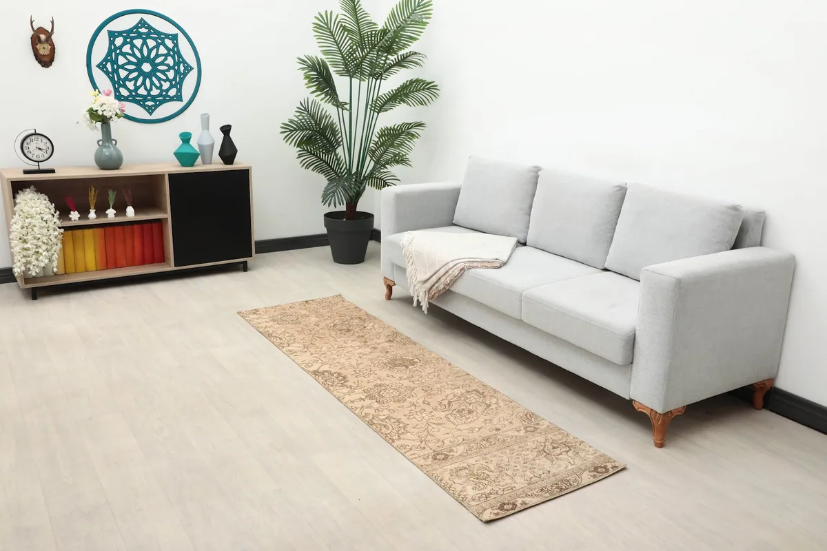 Long shot of the runner in a modern living space with a light gray sofa and wooden furniture.
