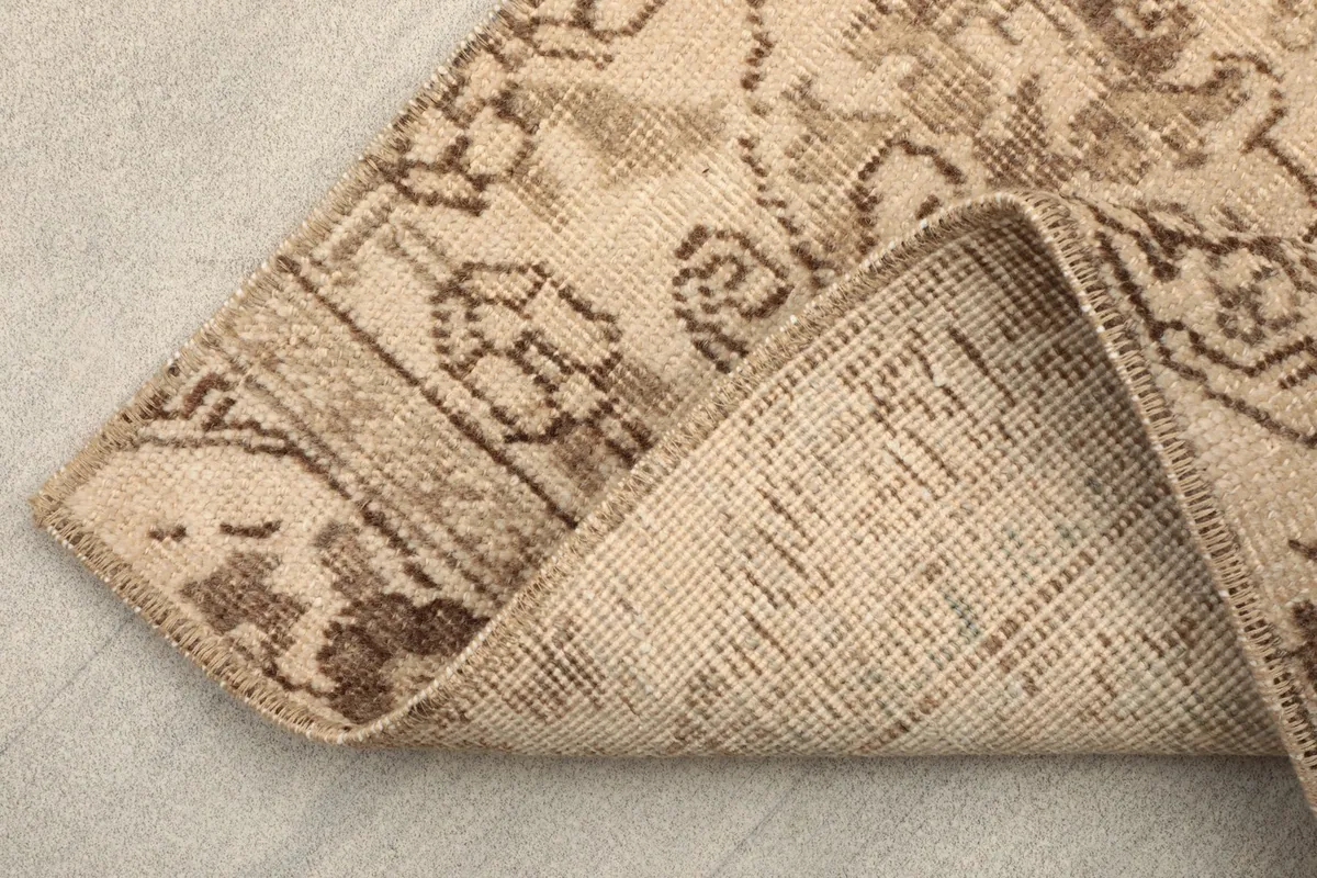 Corner of the runner folded to show the back of the rug, revealing the cotton foundation and knotting.