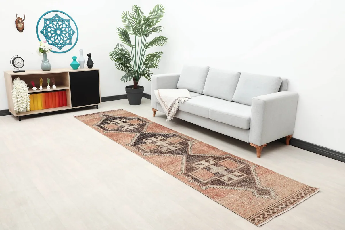 Wide view of the 2'11" x 11'7" vintage rug in a living space, highlighting its long runner shape and colors.