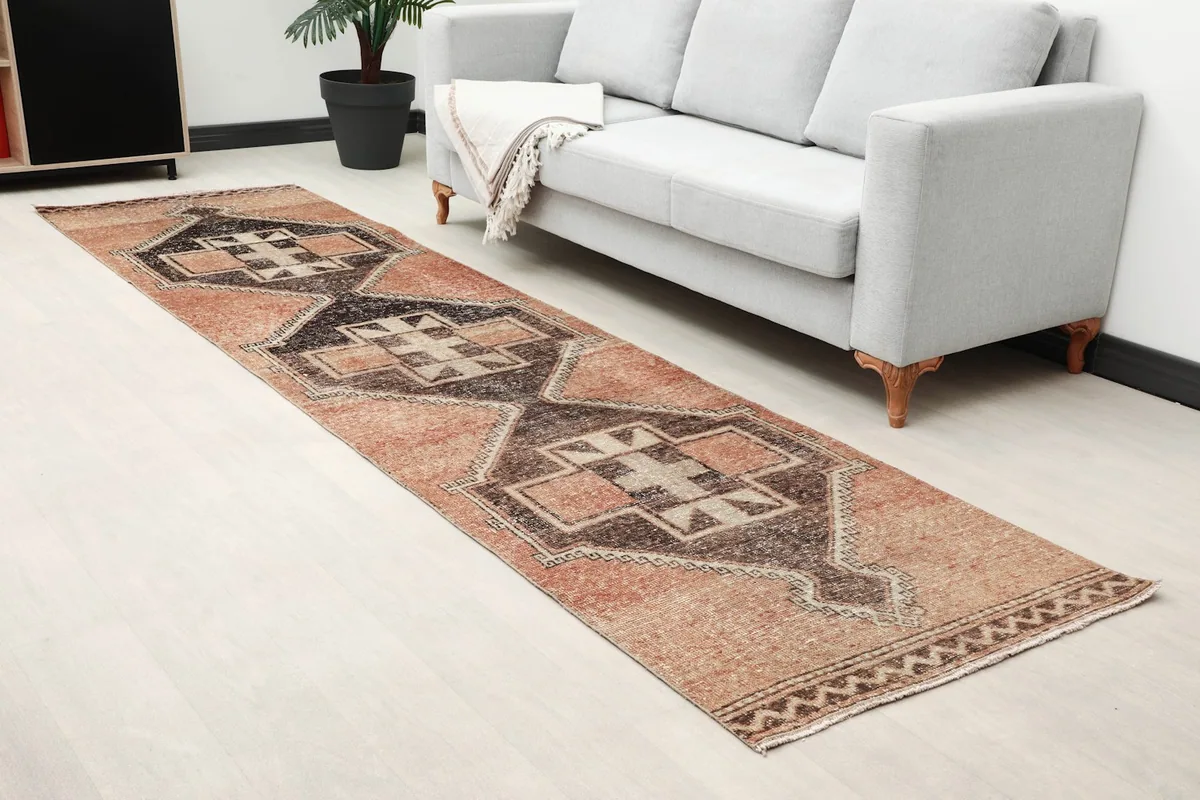 Angled view of the rust and charcoal runner rug extending through a room, adding warmth to the decor.