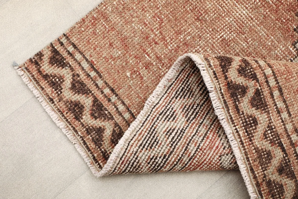 Folded section of the runner, displaying the thickness of the rug and the patterns on the reverse side.
