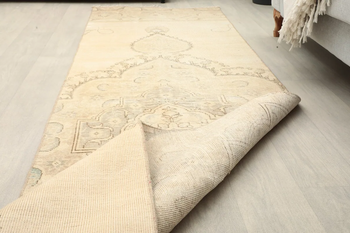 Runner partially rolled, displaying the flexibility of the rug and the back of the foundation