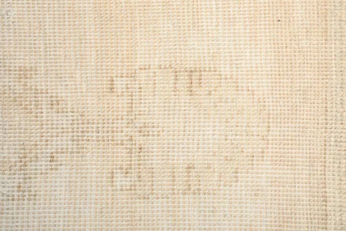 Extreme close-up of the hand-knotted wool pile showing individual knots and faded tan details