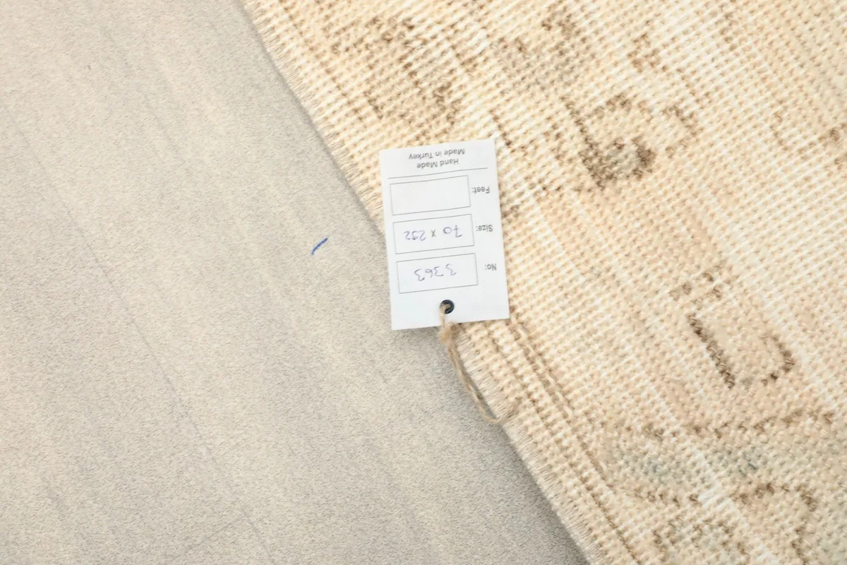Close-up of the product tag indicating rug dimensions and origin, next to the rug's texture