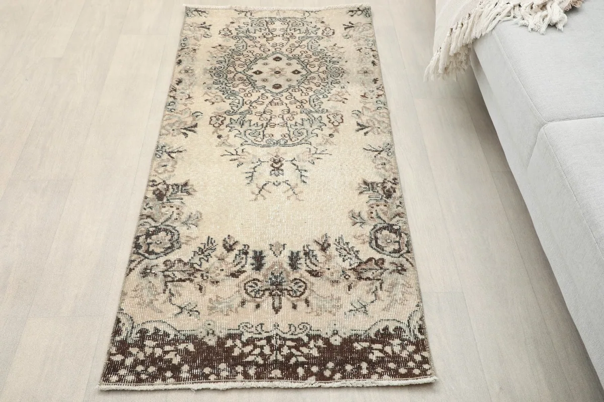 Ivory botanical medallion rug displayed in a living room setting next to a sofa