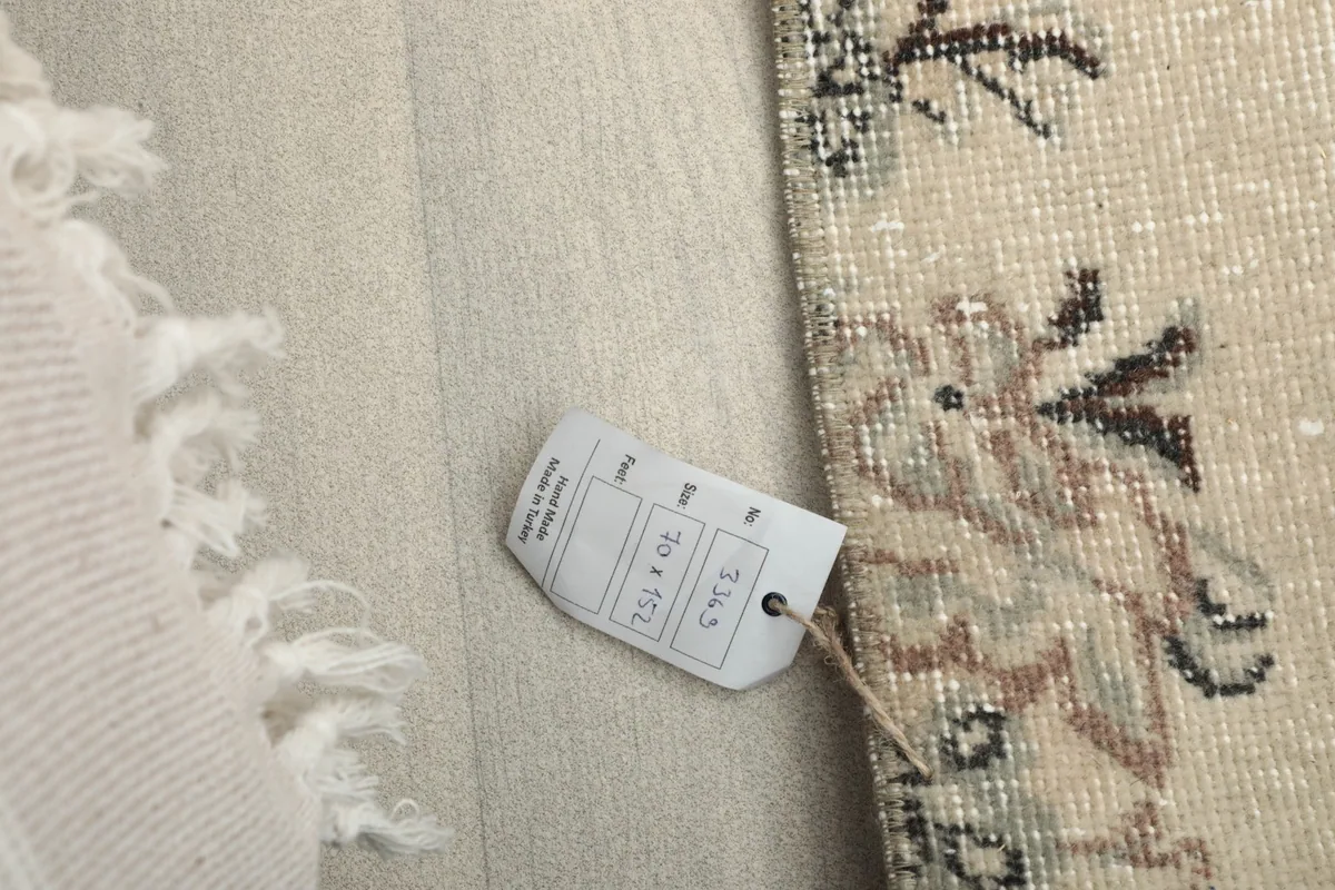 Product tag attached to the rug, displaying size information: 70 x 152 cm and 2'4" x 5'0"