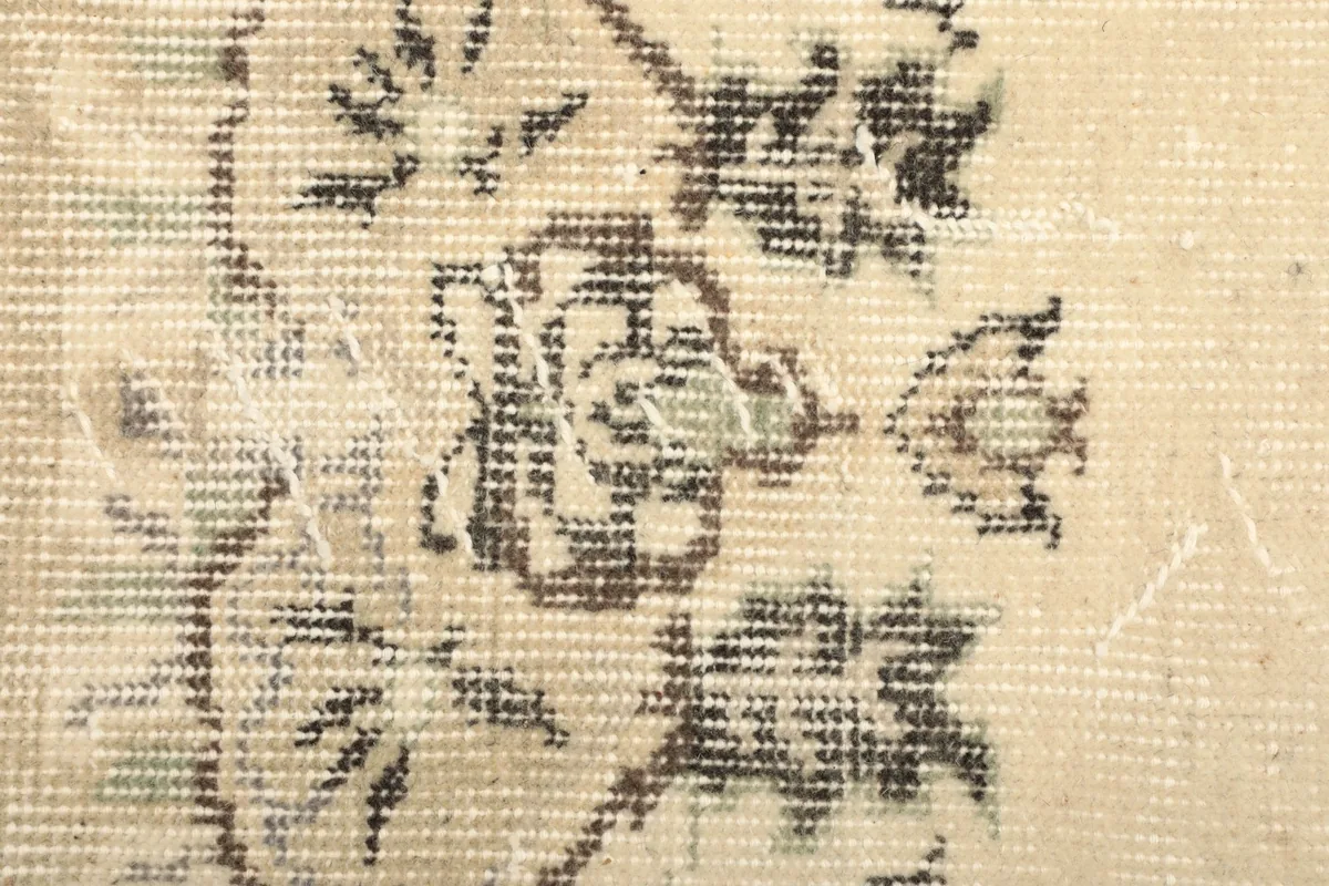 Close-up of the low wool pile, showing the texture and distressed areas of the gray motifs.