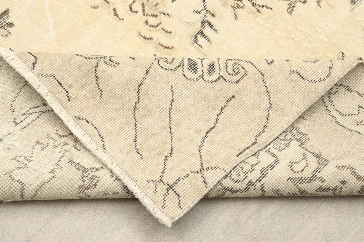 Folded corner revealing the back of the hand-knotted rug, showcasing the cotton foundation.