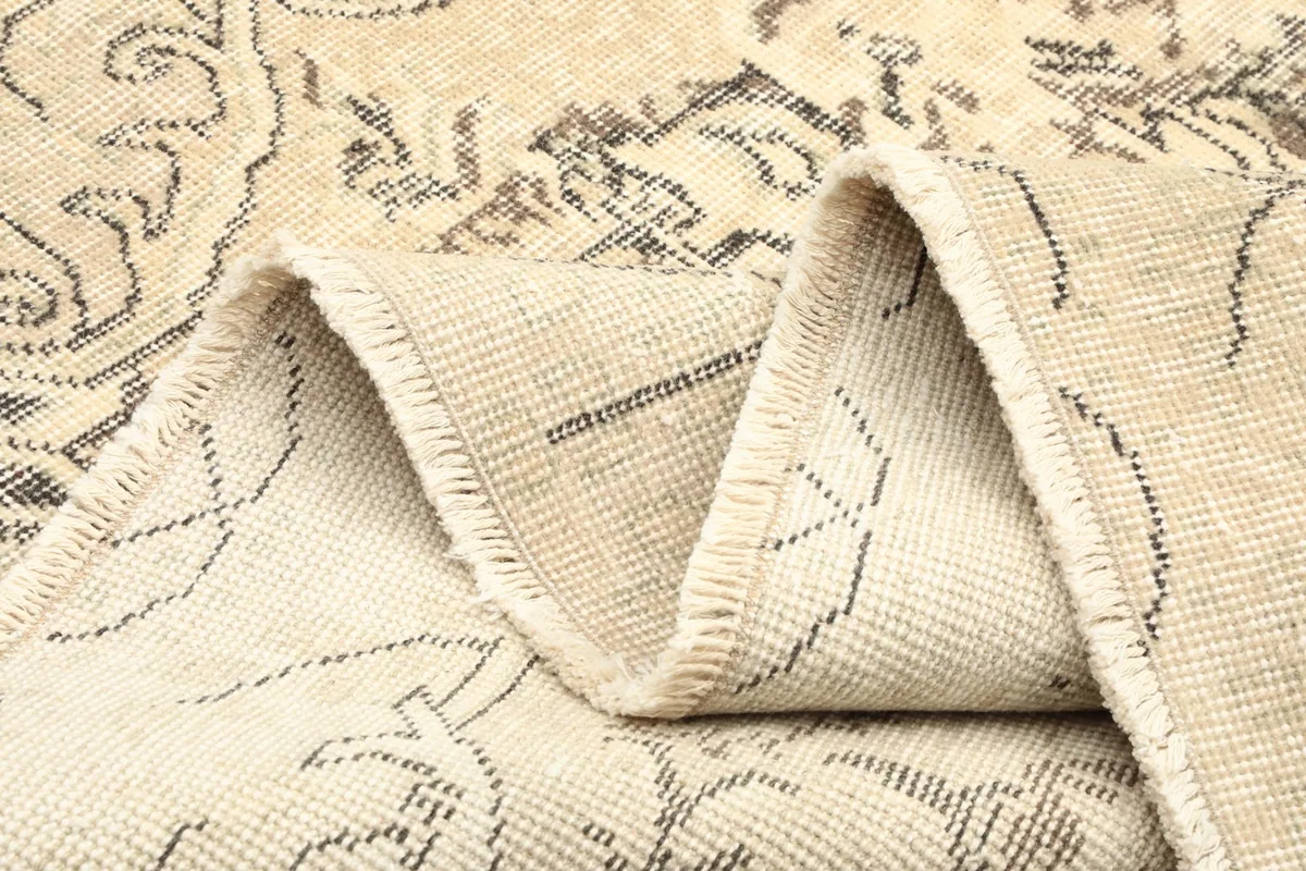 Folded section of the rug, highlighting the soft, pliable nature of the vintage wool material.