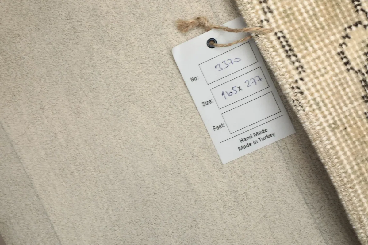Rug tag showing the dimensions 165x277 cm and 'Hand Made in Turkey' information.
