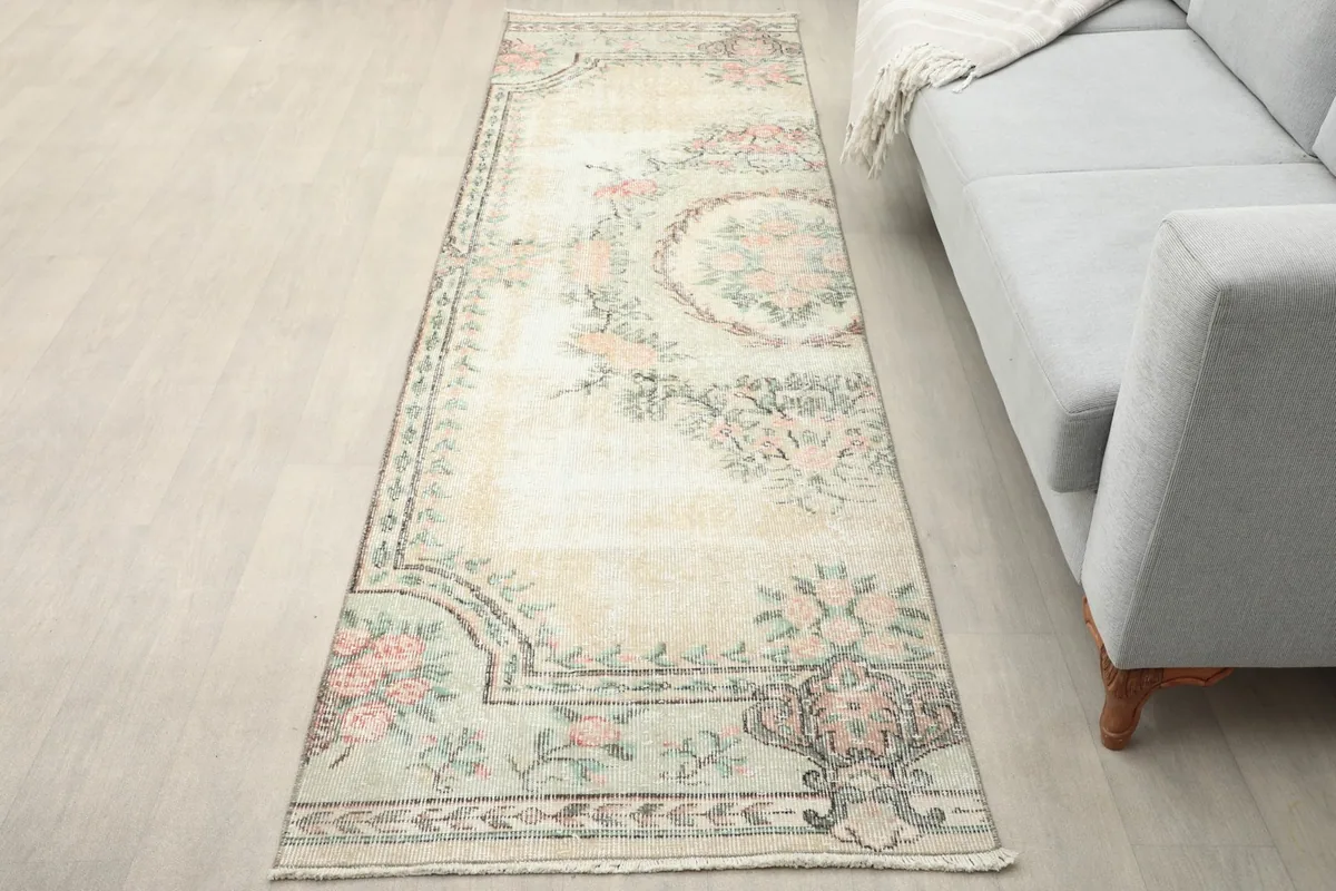 Vintage runner rug laid in a room next to a light gray sofa