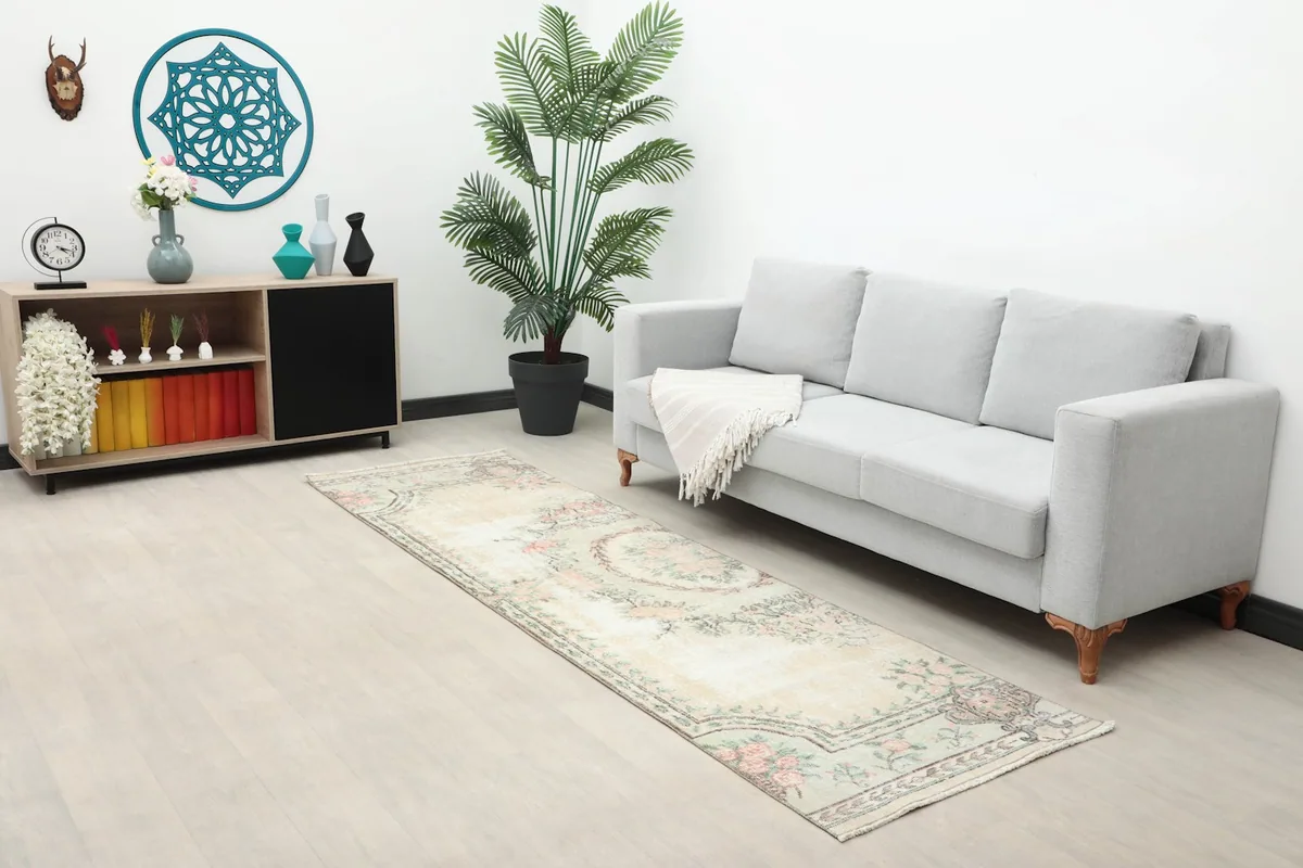 Long shot of the runner rug in a room with a sofa and side cabinet