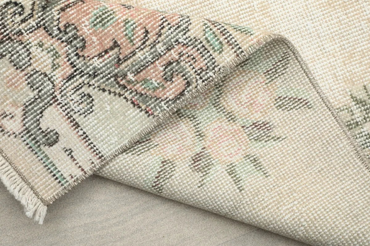 Folded corner of the rug revealing the reverse side and fringe