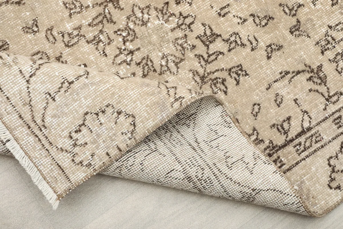 Detail of the rug's fringe and the reverse side, showcasing the hand-knotted craftsmanship