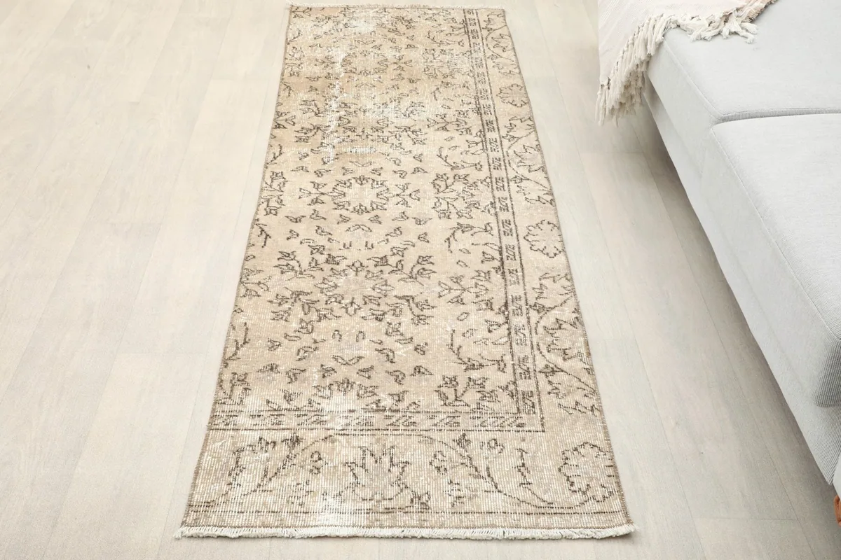 Overhead view of the tan runner rug in a room setting with light flooring