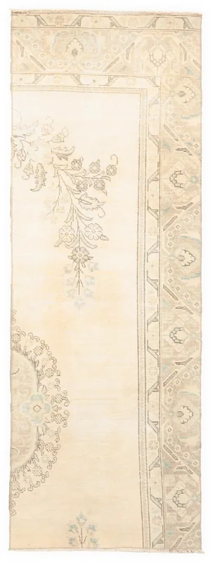 Overhead view of a cream vintage Anatolian runner rug with subtle floral and medallion patterns.