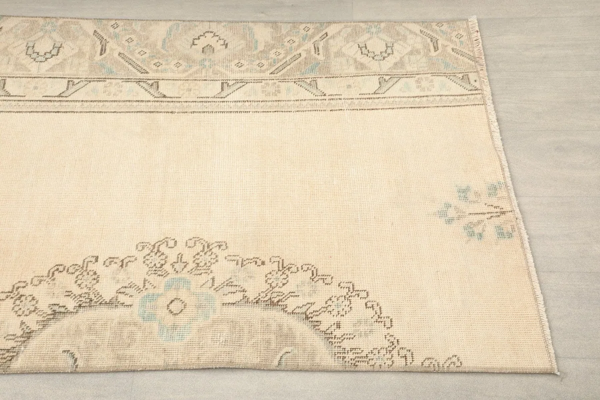 Close-up of the lower section of the rug, showing the faded medallion and border details.