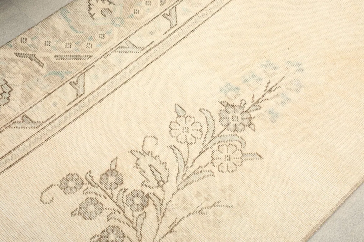 Close-up of the floral motifs on the cream field, showing the subtle blue accents.