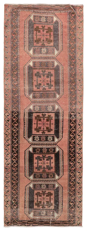Full overhead view of a vintage rose and black geometric runner rug on a white background.
