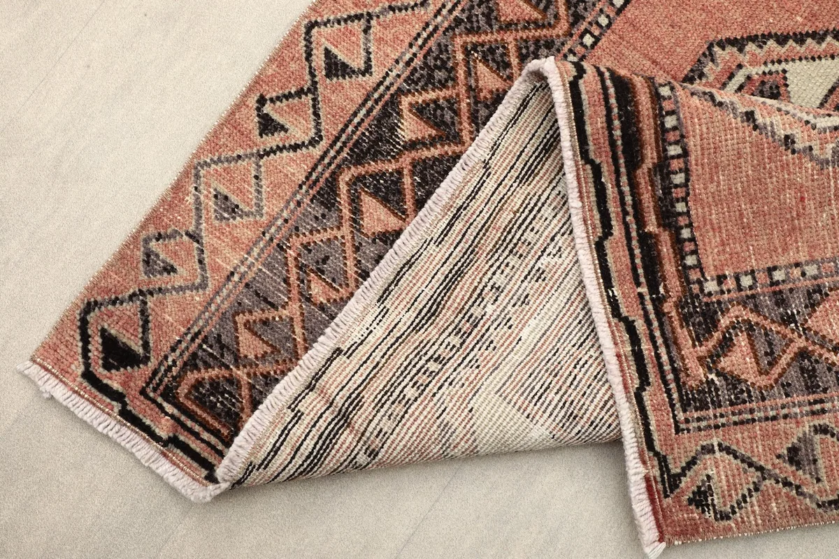 View of the rug folded to show the wool pile texture and cotton foundation.
