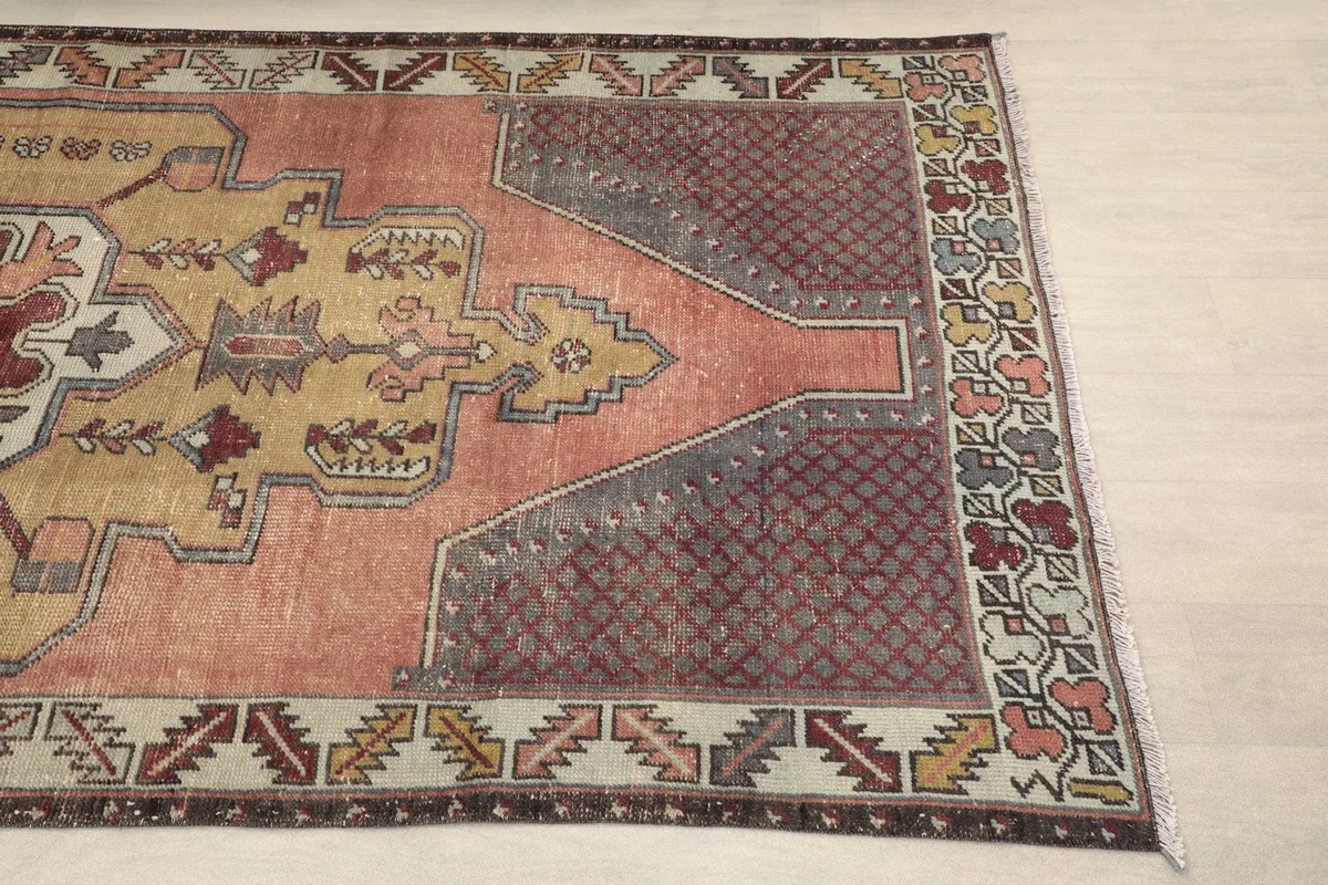 Close-up of the rug's left side, showing the rose field, gold medallion, and ivory border