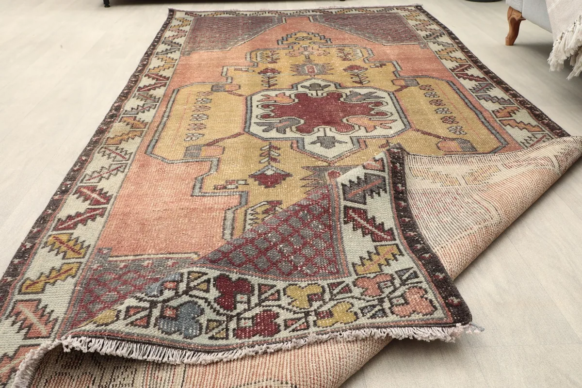 View of the rug with a corner folded, showing the low pile and intricate patterns