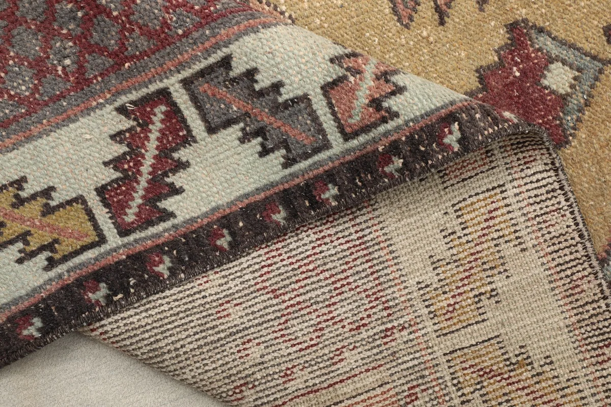 Underside of the hand-knotted wool rug, revealing the cotton foundation