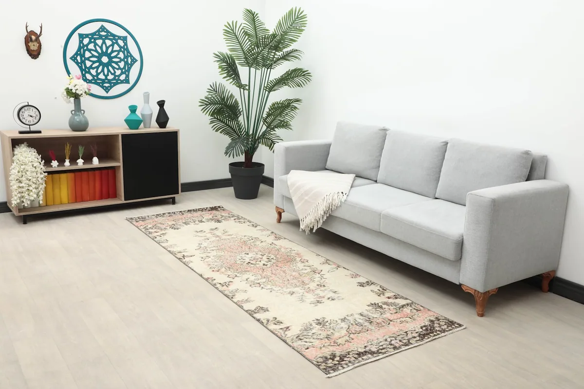 Full room view showing the runner rug extending from a sofa towards a cabinet
