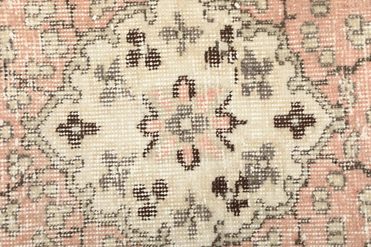Extreme close-up showing the low wool pile and hand-knotted texture of the rug
