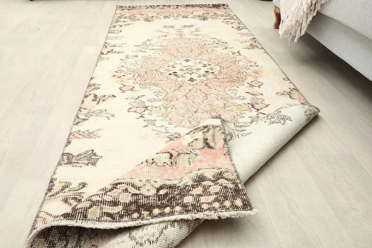Runner rug with one end folded back, showcasing the full length and design on the floor
