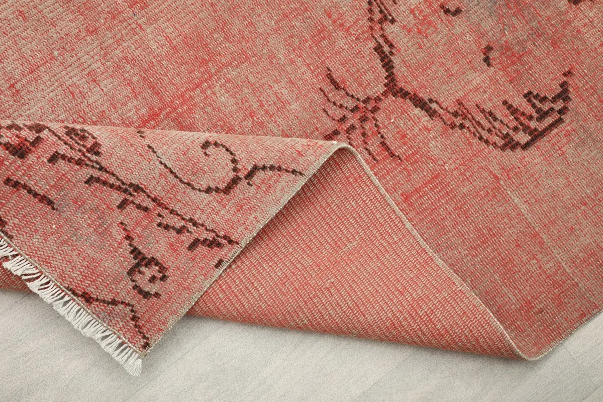 Close-up of the folded rug, highlighting the hand-knotted construction and fringe.