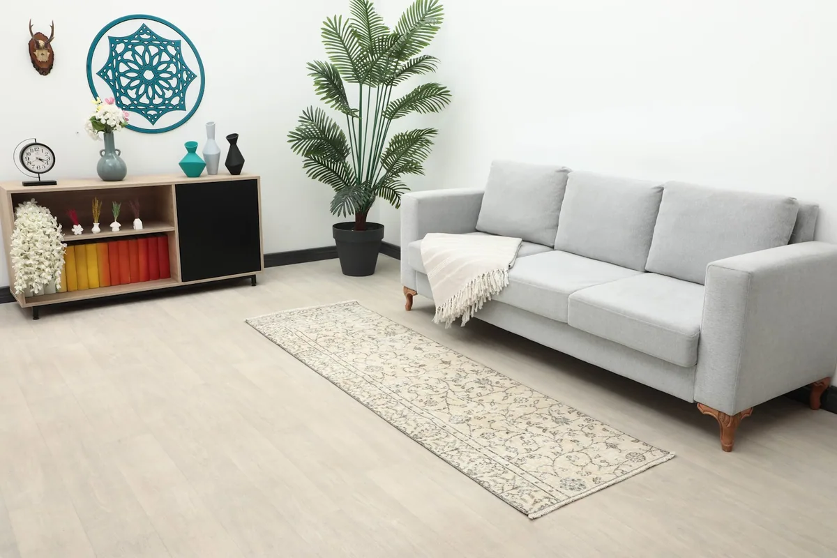 Long shot of the beige and charcoal runner rug placed in a modern living space with a sofa and decor